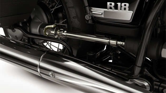 We see the round exhaust pipe, the open drive shaft, and the double cradle frame.